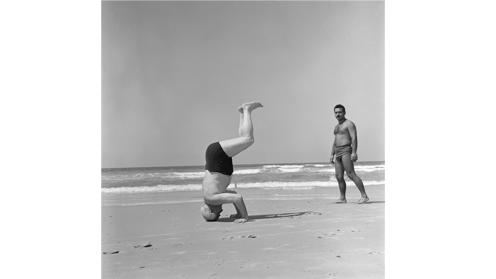 בן גוריון עומד על הראש בחוף הרצליה, 1957. צילום: פאול גולדמן